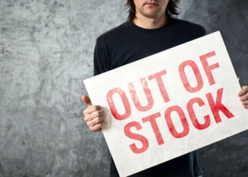 Out of Stock sign in hands of storage employee, shortage in supply chain