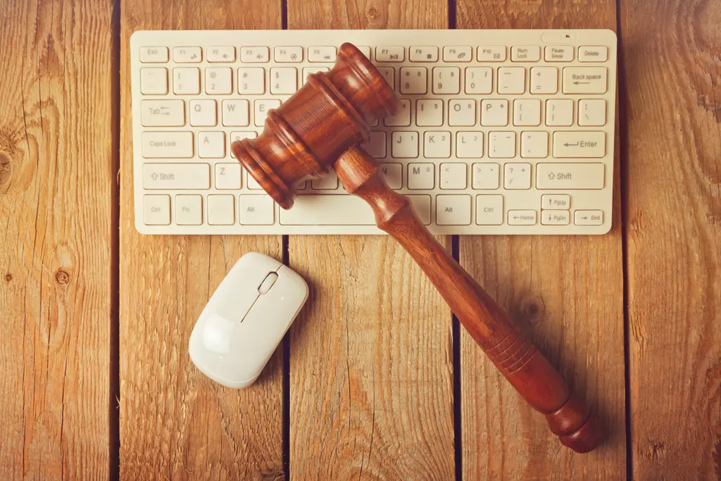 Judge gavel and computer keyboard on wooden vintage background