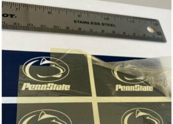 Researchers developed a polymer capacitor by combining two cheap, commercially available plastics. The new polymer capacitor makes use of the transparent material — pictured here, with vintage Penn State athletic marks visible through it — to store four times the energy and withstand significantly more heat.  Credit: Penn State